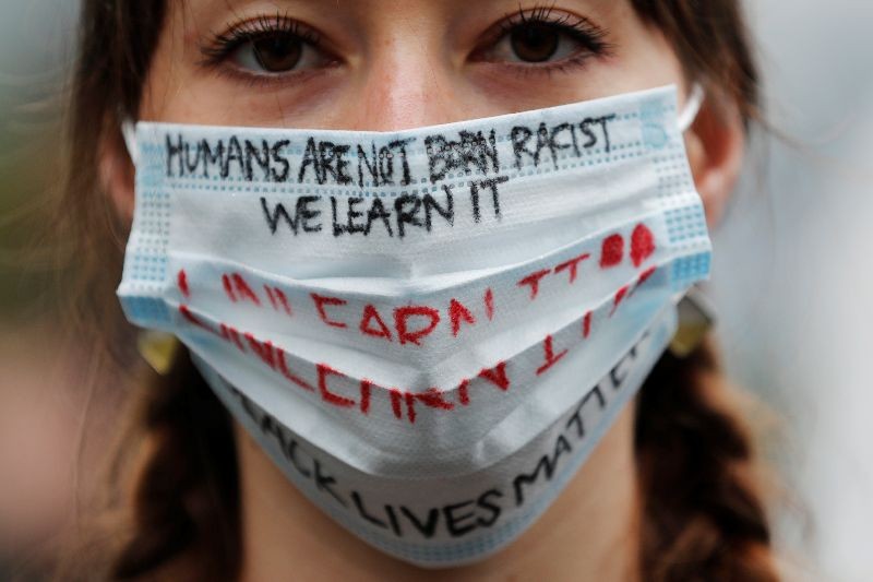 Elly Hawkins wearing a face mask bearing slogans poses to a camera during a Black Lives Matter protest following the death in Minneapolis police custody of George Floyd, in Tokyo, Japan June 14, 2020. REUTERS/Kim Kyung-Hoon